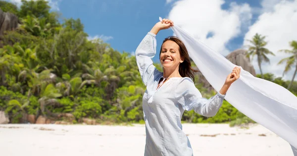 Femme heureuse avec châle agitant dans le vent sur la plage — Photo