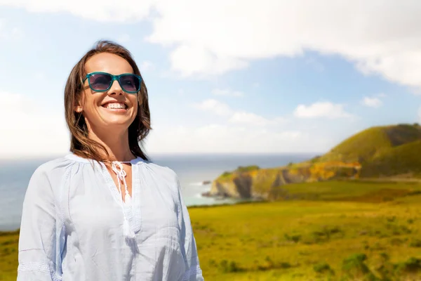 Улыбающаяся женщина в солнцезащитных очках над большим побережьем — стоковое фото