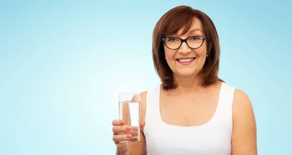 Bardak su ile gözlüklü kadın kıdemli — Stok fotoğraf