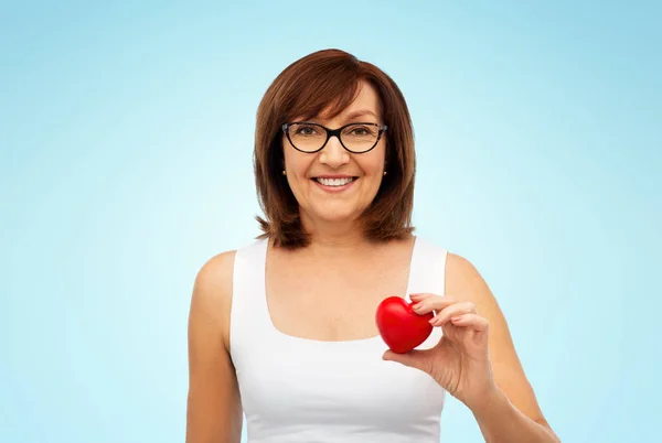 Retrato de mulher sênior sorridente segurando coração vermelho — Fotografia de Stock