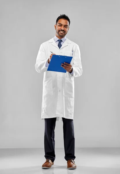 Улыбающийся индийский врач или ученый с планшетом — стоковое фото
