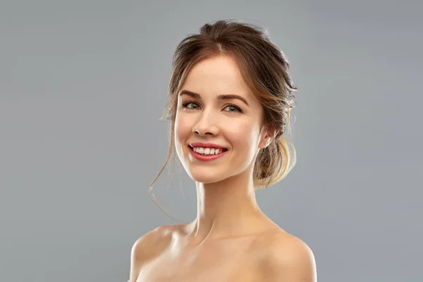 Sonriente joven mujer sobre gris fondo — Foto de Stock