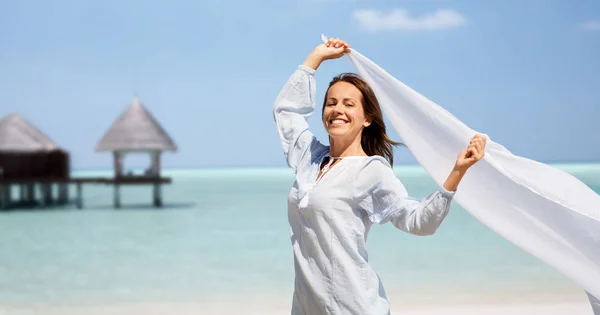 Šťastná žena s šátek mávat ve větru na pláži — Stock fotografie