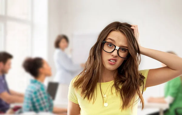 Verwirrtes Teenager-Mädchen mit Brille in der Schule — Stockfoto