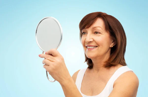 Portret uśmiechniętej starszej kobiety z lustrem — Zdjęcie stockowe