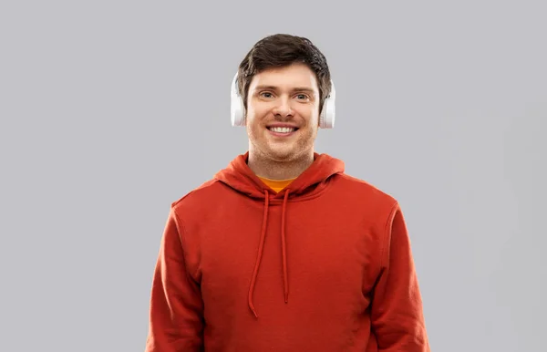 Joven feliz en auriculares y sudadera con capucha roja —  Fotos de Stock