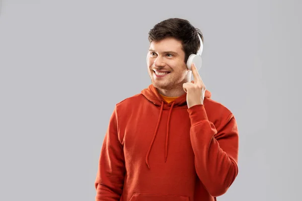 Szczęśliwy młody człowiek w słuchawki i czerwona Bluza z kapturem — Zdjęcie stockowe
