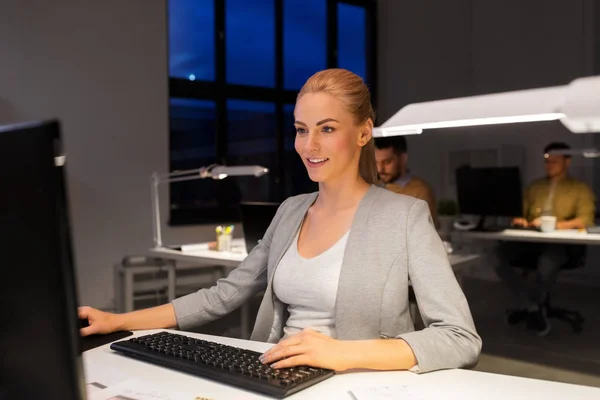 Mujer de negocios que trabaja en la computadora en la oficina nocturna — Foto de Stock