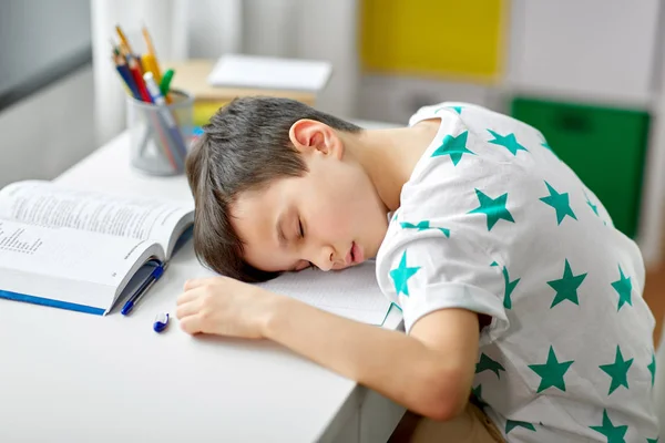 Trött student pojken sover på bordet hemma — Stockfoto