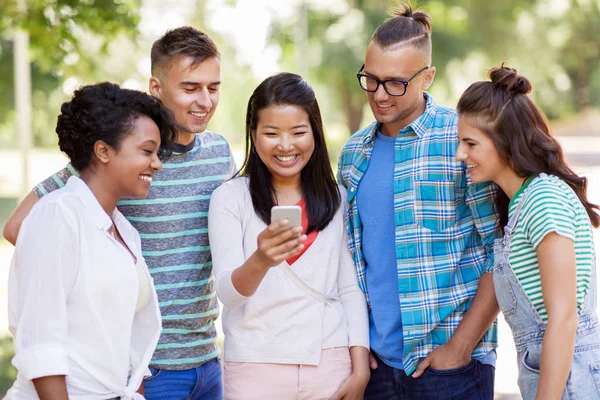Grupo de amigos felizes com smartphone ao ar livre — Fotografia de Stock