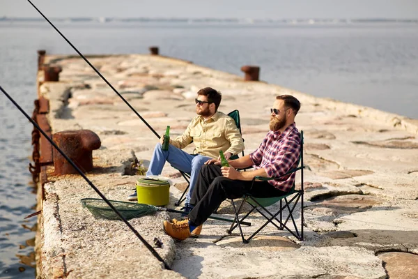 Amigos felizes pesca e beber cerveja no cais — Fotografia de Stock