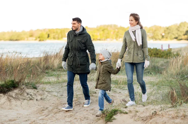 Feliz familia caminando a lo largo de la playa otoño — Foto de Stock