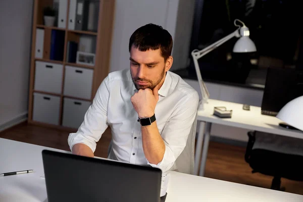 Homem de negócios com laptop trabalhando no escritório da noite — Fotografia de Stock