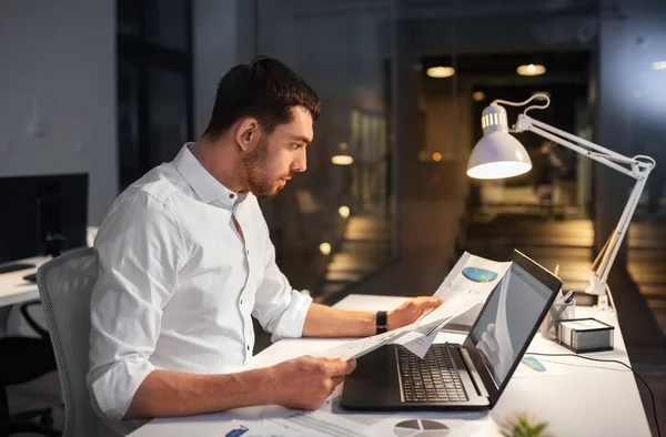 Бизнесмен с ноутбуком работает в ночном офисе — стоковое фото