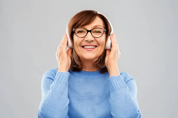 Femme âgée dans les écouteurs écouter de la musique — Photo