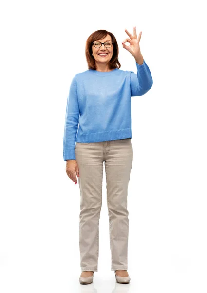 Šťastná starší žena v brýlích ukazuje značka ok ruky — Stock fotografie