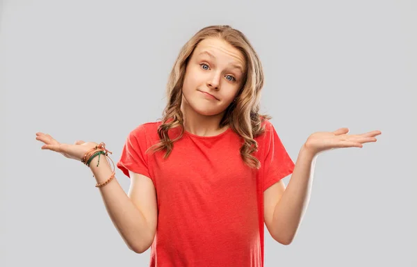 Domandando adolescente in rosso t-shirt scrollando le spalle — Foto Stock