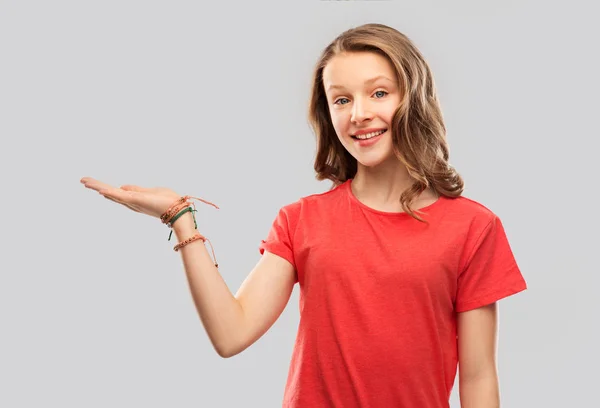 Sorridente adolescente segurando a mão vazia — Fotografia de Stock