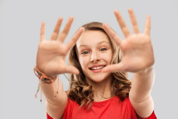 Glad tonårig flicka i röd t-shirt ger hög fem — Stockfoto