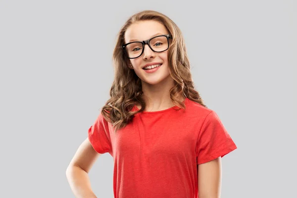 Niña estudiante sonriente en gafas y camiseta roja —  Fotos de Stock