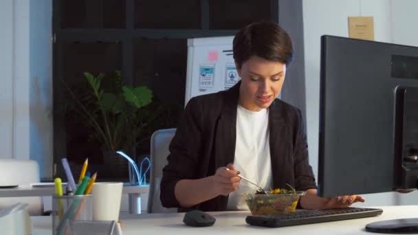 Бізнес-леді їсть і працює в нічному офісі — стокове відео