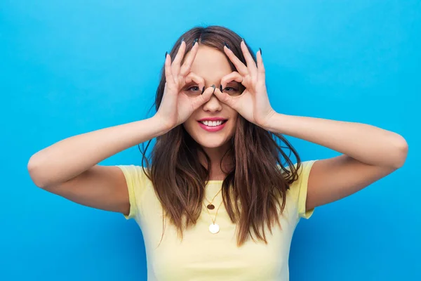 Jovem mulher olhando através de óculos de dedo — Fotografia de Stock