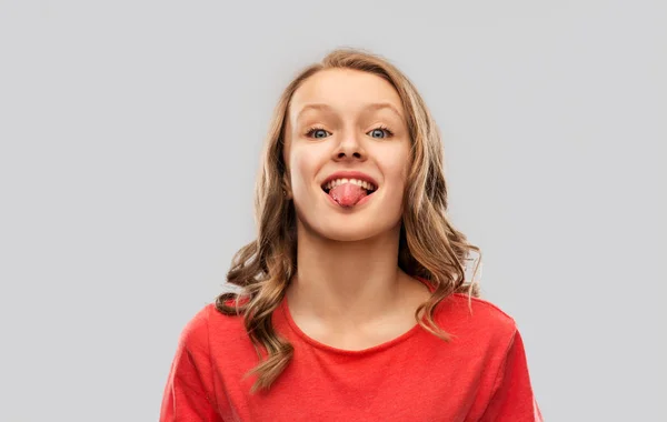 Kırmızı t-shirt gösteren dil komik genç kız — Stok fotoğraf