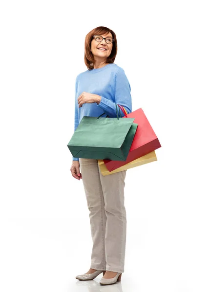 Ηλικιωμένη γυναίκα με τσάντες ψώνια απομονωμένη σε λευκό — Φωτογραφία Αρχείου