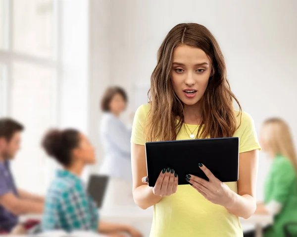 Astonished student girl with tablet pc at school — Stock Photo, Image