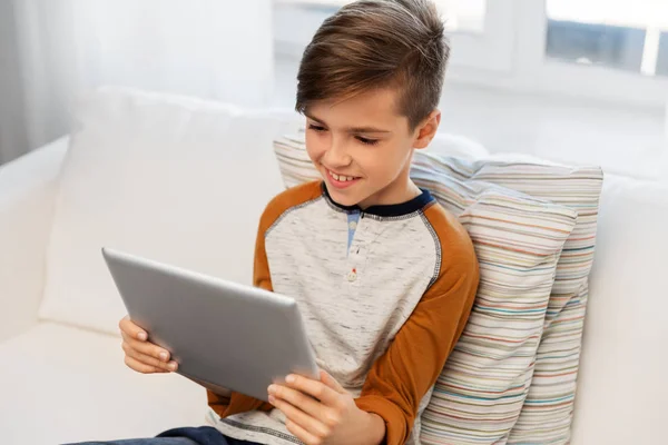 Sorrindo menino com tablet pc computador em casa — Fotografia de Stock