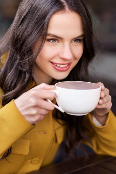 Teenage girl drinking hot chocolate at city cafe — Stock Photo, Image