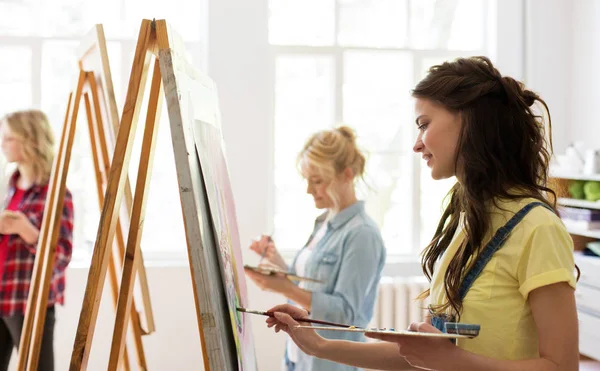 Woman with easel painting at art school studio — Stock Photo, Image