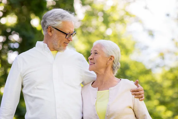 Счастливая пожилая пара обнимается в летнем парке — стоковое фото
