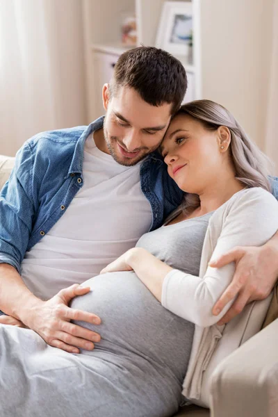 Homme étreignant femme enceinte à la maison — Photo