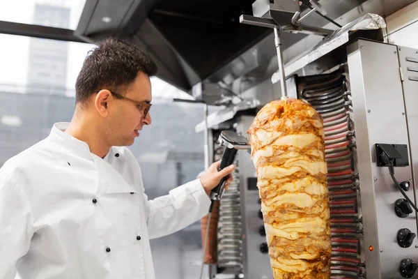 Chef tranchant la viande doner de la broche au kebab shop — Photo