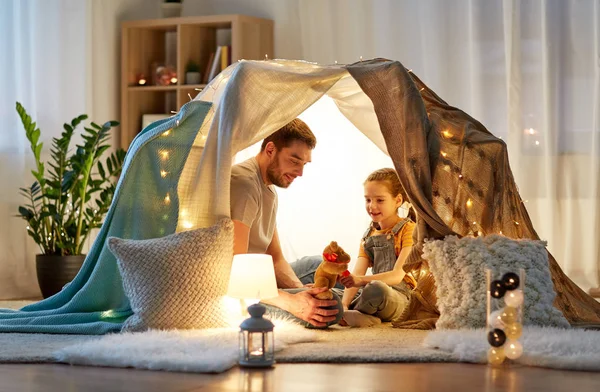 Família feliz brincando com brinquedo na tenda das crianças em casa — Fotografia de Stock