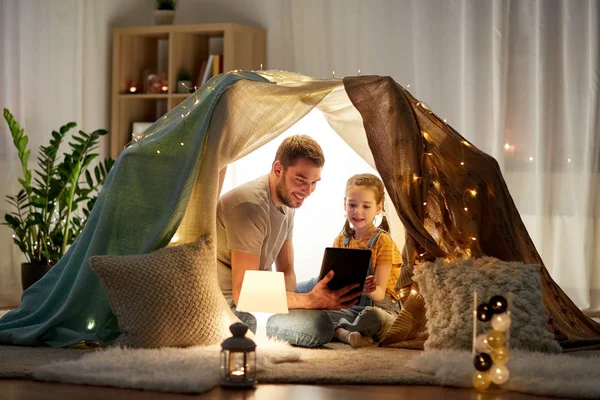 Семья с планшетным ПК в детской палатке дома — стоковое фото