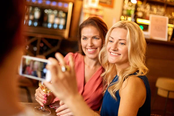 Donna immaginando amici da smartphone al wine bar — Foto Stock