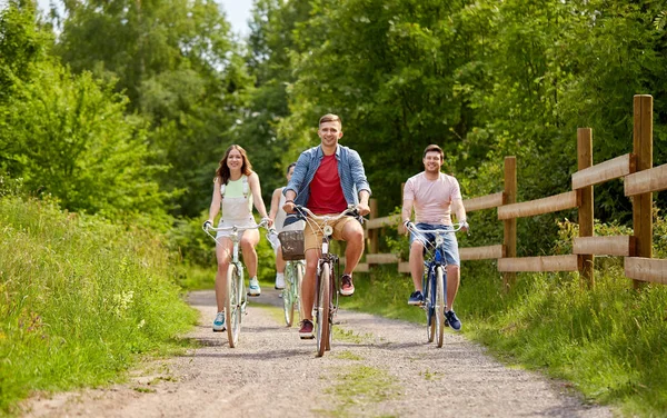 Amigos felices montando bicicletas de engranaje fijo en verano — Foto de Stock