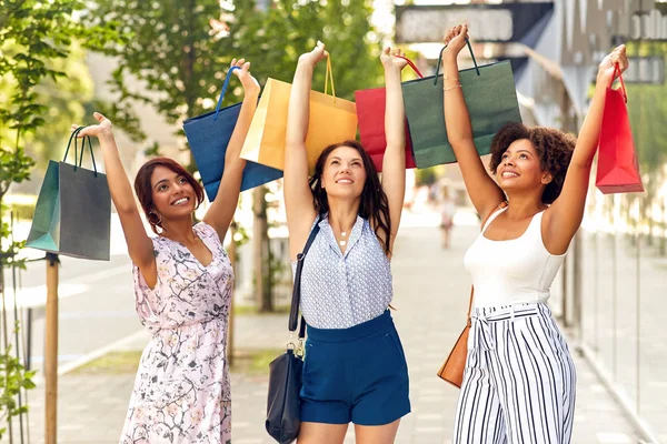 Glada kvinnor med kassar på gata — Stockfoto