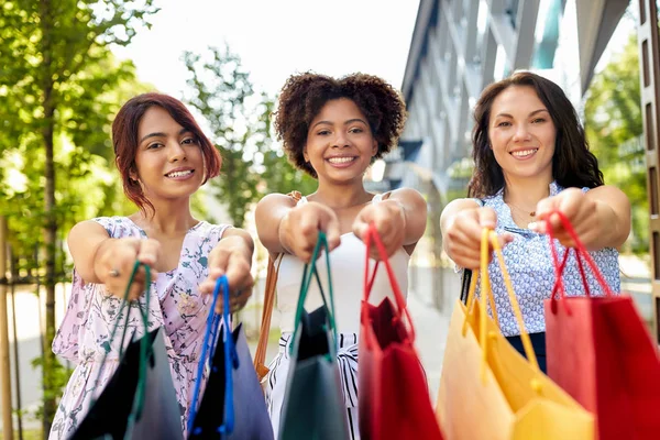 Mulheres felizes com sacos de compras na cidade — Fotografia de Stock