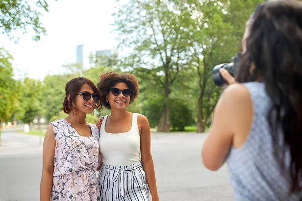 Mujer fotografiando a sus amigos en el parque de verano — Foto de Stock