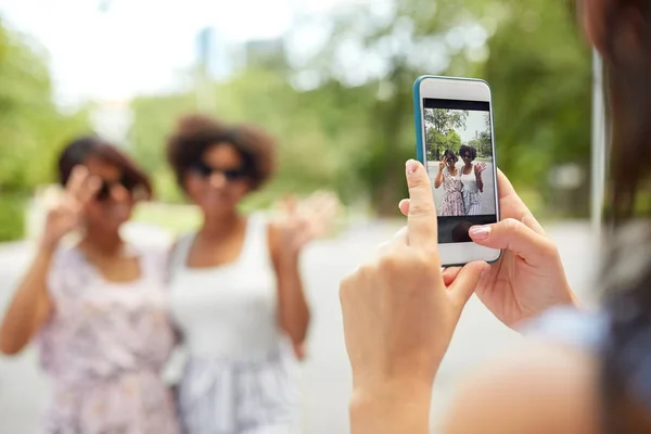 Mujer fotografiando a sus amigos en el parque de verano —  Fotos de Stock