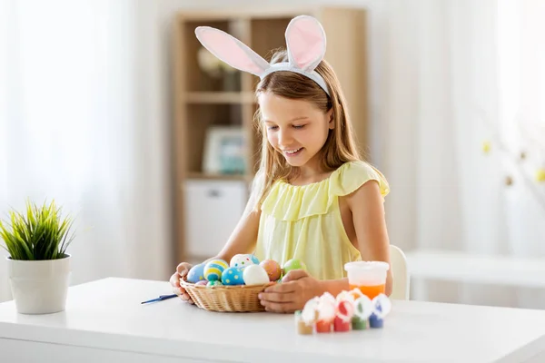 Happy girl with colored easter eggs at home — Stock Photo, Image