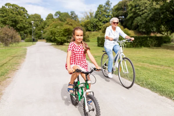 Babcia i wnuczka, jazda na rowerze w parku — Zdjęcie stockowe