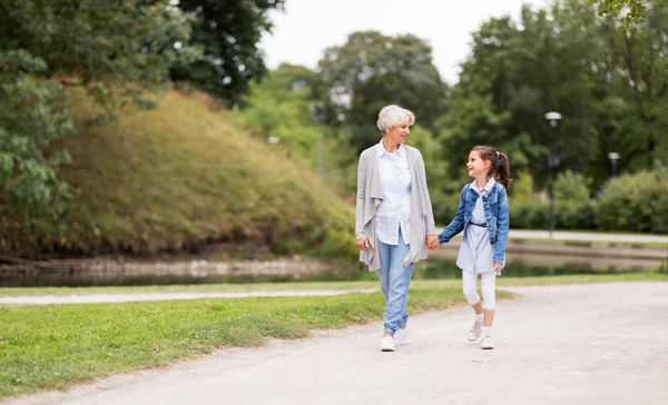 Grandmother and granddaughter walking at park — Stock Photo, Image