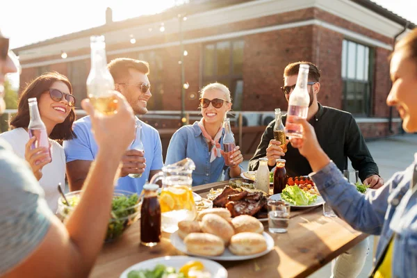 Amigos felices con bebidas o barbacoa en la azotea — Foto de Stock