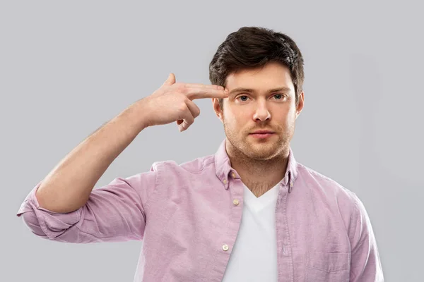 Bored man making headshot by finger gun gesture — Stock Photo, Image