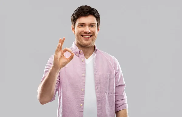 Lächelnder junger Mann zeigt Handzeichen — Stockfoto