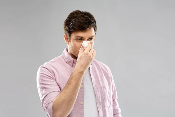 Hombre malsano con servilleta de papel que sopla la nariz — Foto de Stock